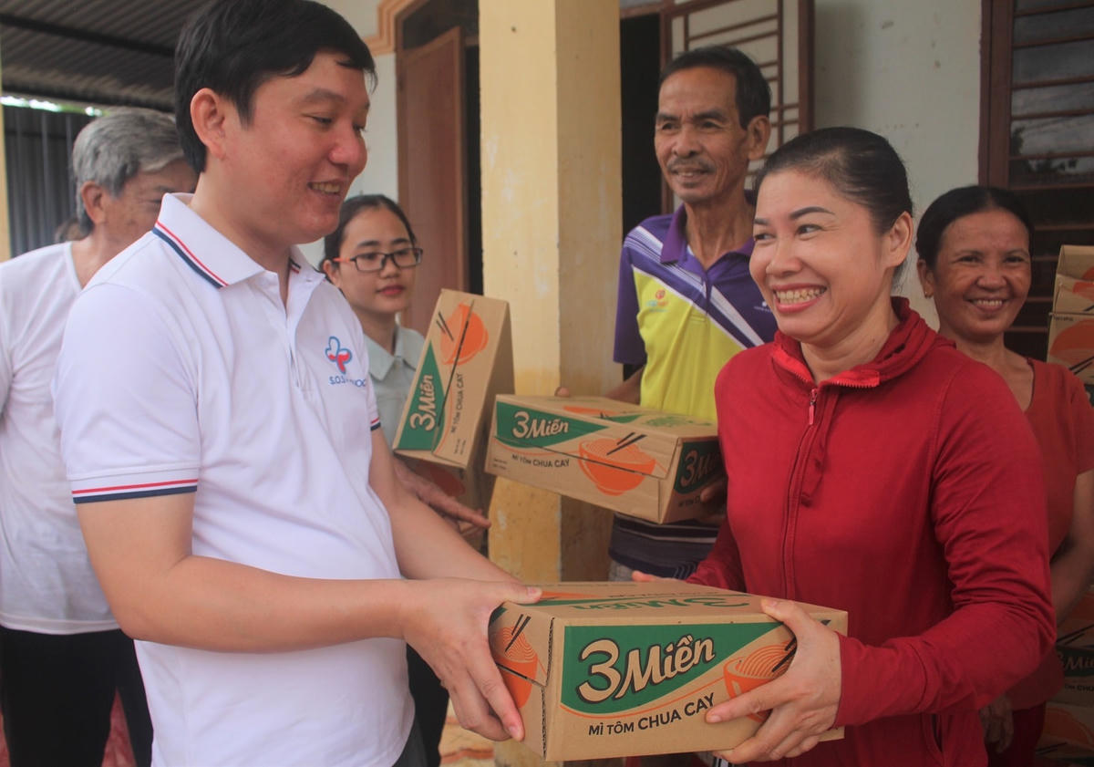 Ông Huỳnh Văn Khái trao quà cho bà con vùng lũ TP Tam Kỳ.