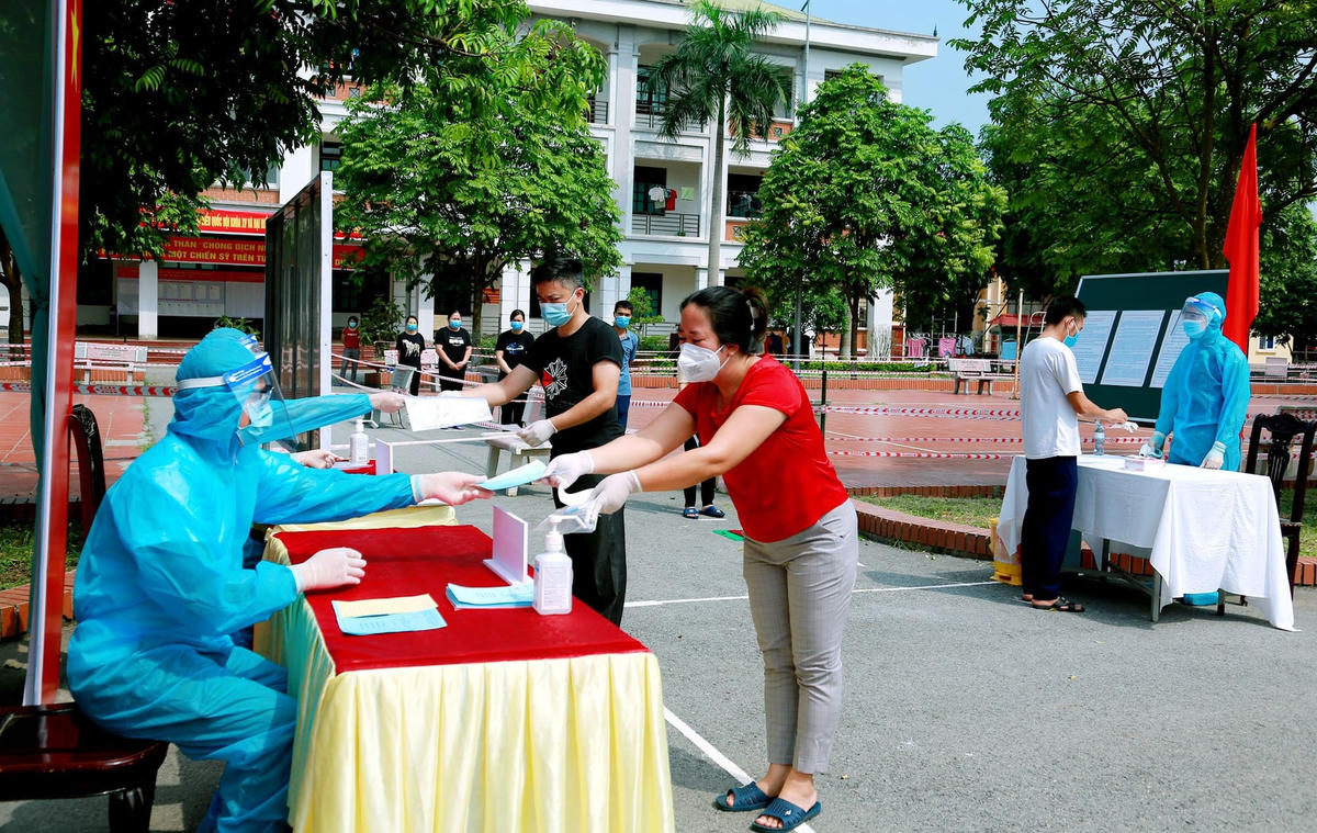 Cử tri đeo khẩu trang, di chuyển theo hàng một chiều, dừng đúng vạch giữ khoảng cách an toàn và đến bàn phát phiếu, khử khuẩn tay, trình thẻ cử tri. 