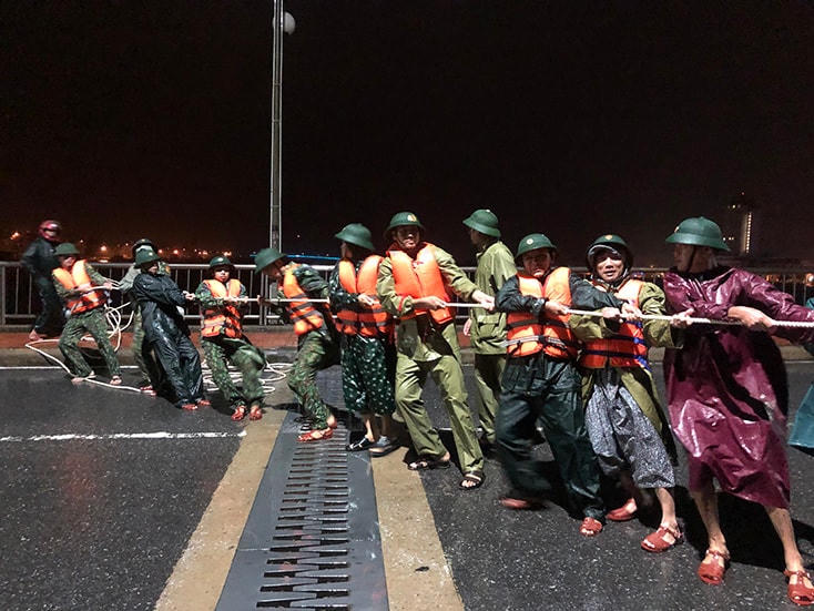 Bộ đội biên phòng Đồn Nhật Lệ giúp ngư dân kéo chiếc tàu cá bị đứt dây neo vào bờ.