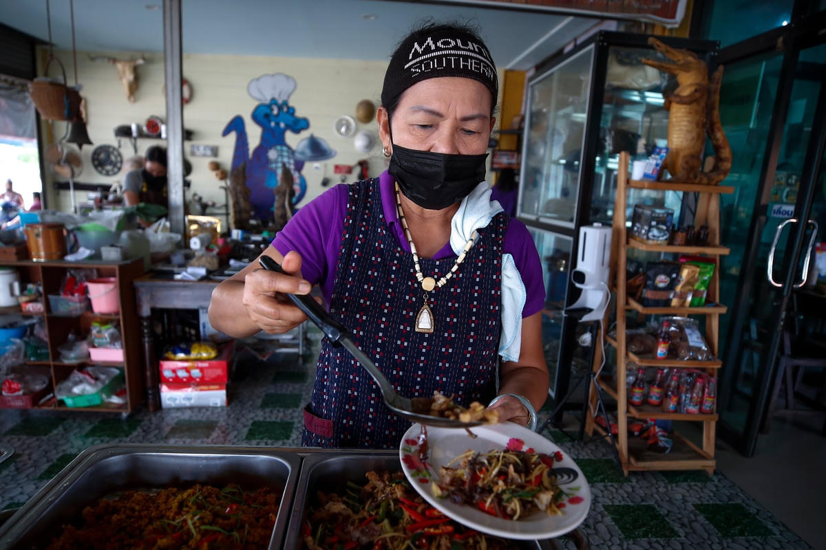 Nữ đầu bếp của nhà hàng đang phục vụ món ăn ra đĩa. Ảnh: Diego Azubel / EPA.