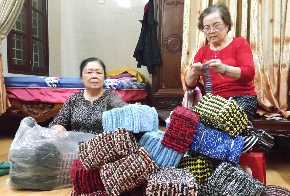 Bà Lê Thị Mai (bên trái) cùng thành viên nhóm thiện nguyện đan khăn, mũ len tặng học sinh các trường nội trú miền núi và trẻ em khuyết tật ở Hà Nội.