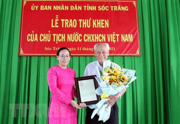 Phó Chủ tịch UBND tỉnh Sóc Trăng Huỳnh Thị Diễm Ngọc trao thư khen của Chủ tịch nước cho ông Trần Cang. (Ảnh: Trung Hiếu/TTXVN).