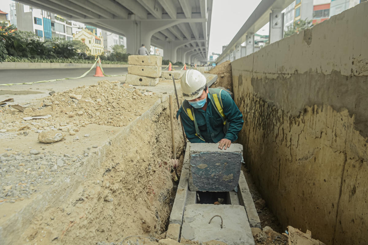 Hệ thống thoát nước, bó vỉa ngay dưới chân các nhánh lên xuống cầu cạn đang tăng tốc triển khai tại khu vực nút giao đường Phạm Văn Đồng, Hoàng Quốc Việt và Cổ Nhuế.