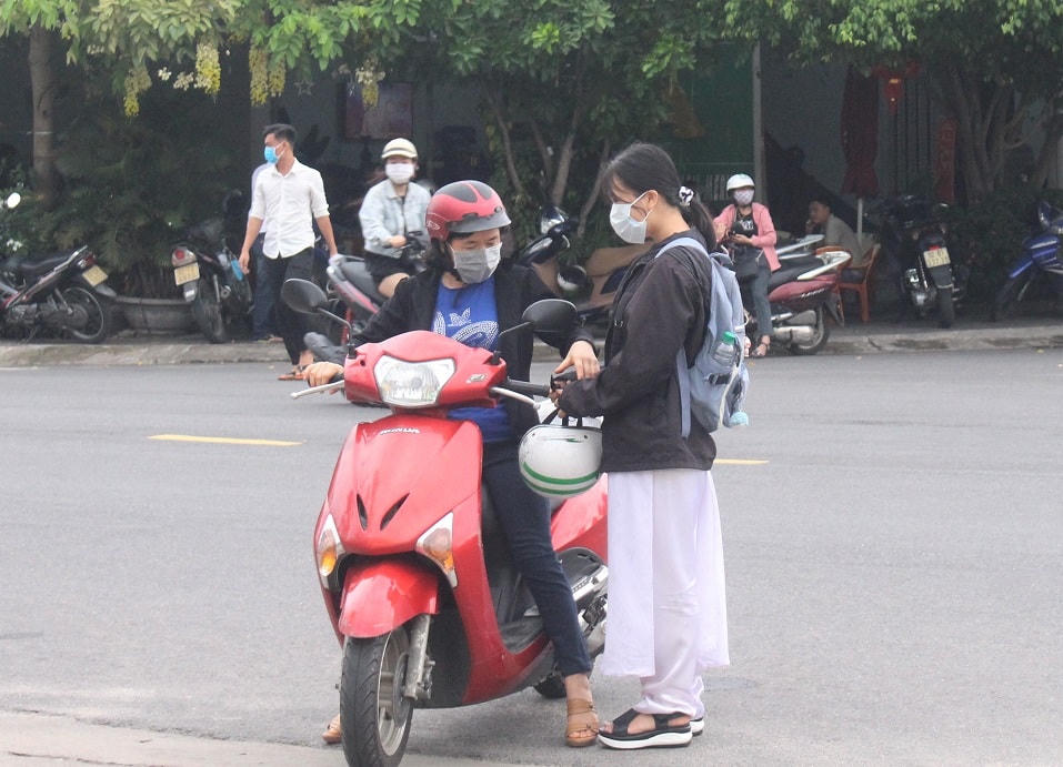 Phụ huynh đưa con mình đến điểm thi.