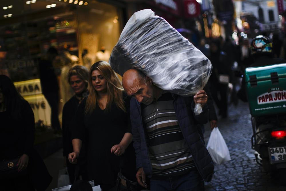  Người đàn ông mang vác hàng hóa trong một khu chợ ở thành phố Istanbul, Thổ Nhĩ Kỳ. Ảnh: AP.