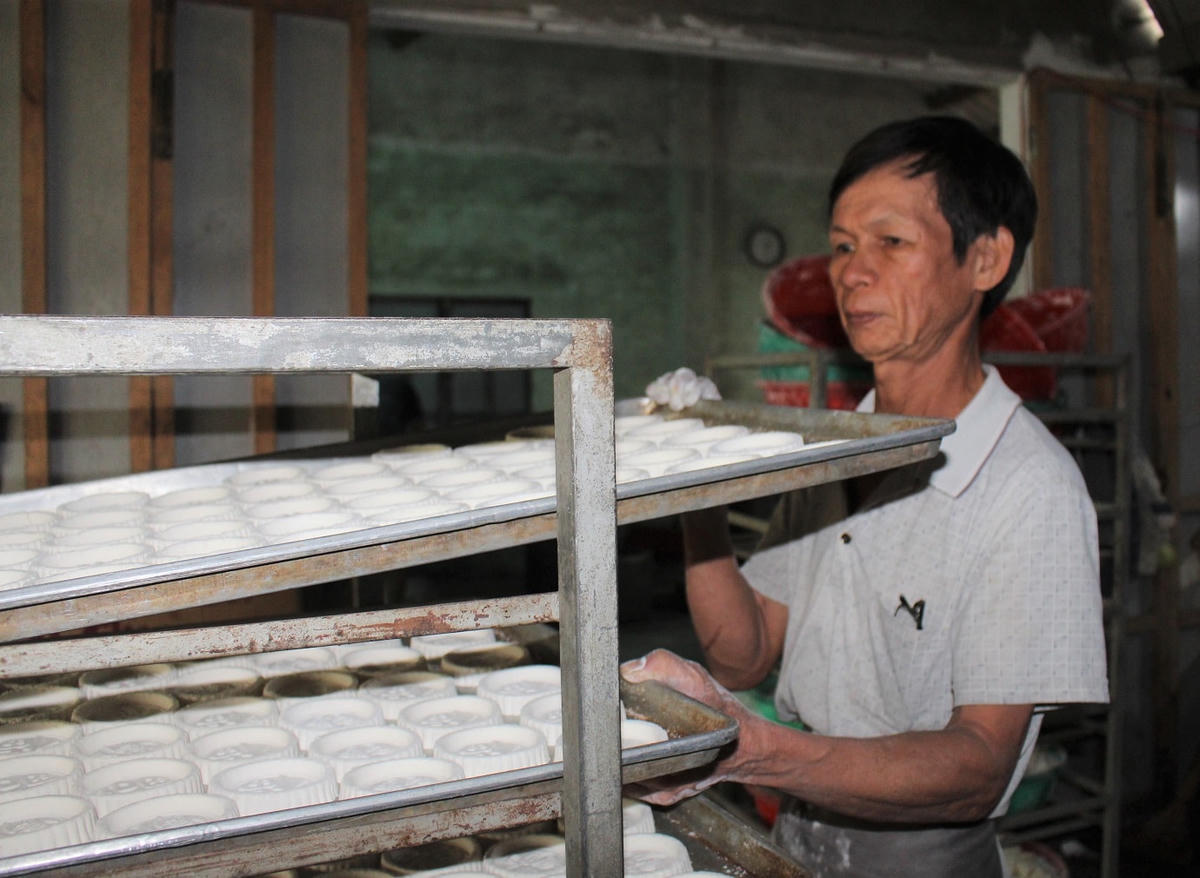 Ông Huỳnh Văn Trung chuẩn bị đưa bánh in vào lò nấu.