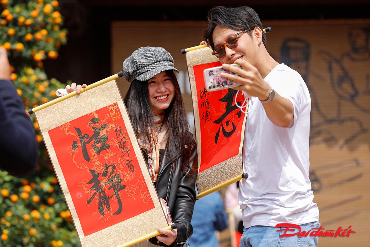 Anh Đức người Sài Gòn ra Hà Nội đón Tết chụp ảnh kỷ niệm với bạn gái sau khi xin được chữ đầu năm.
