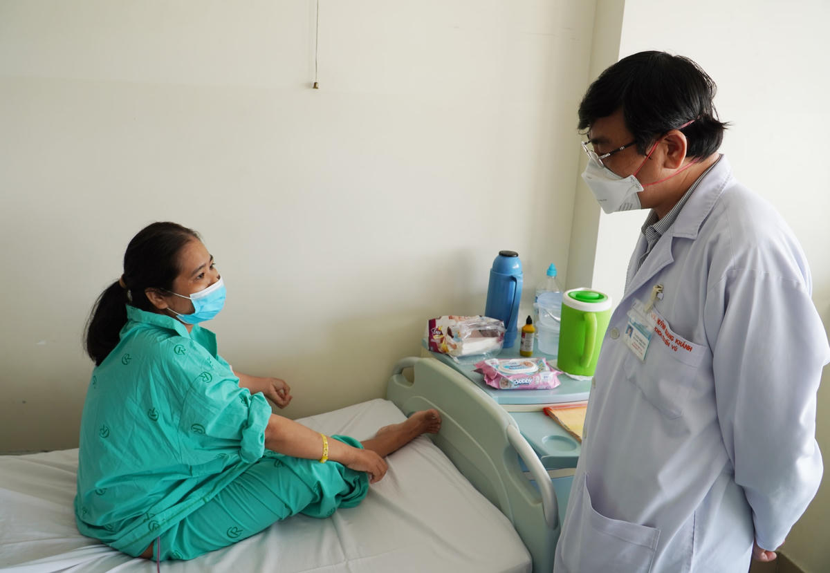 Bác sĩ thăm hỏi sức khỏe của bệnh nhân nữ có khối u vú khổng lồ.