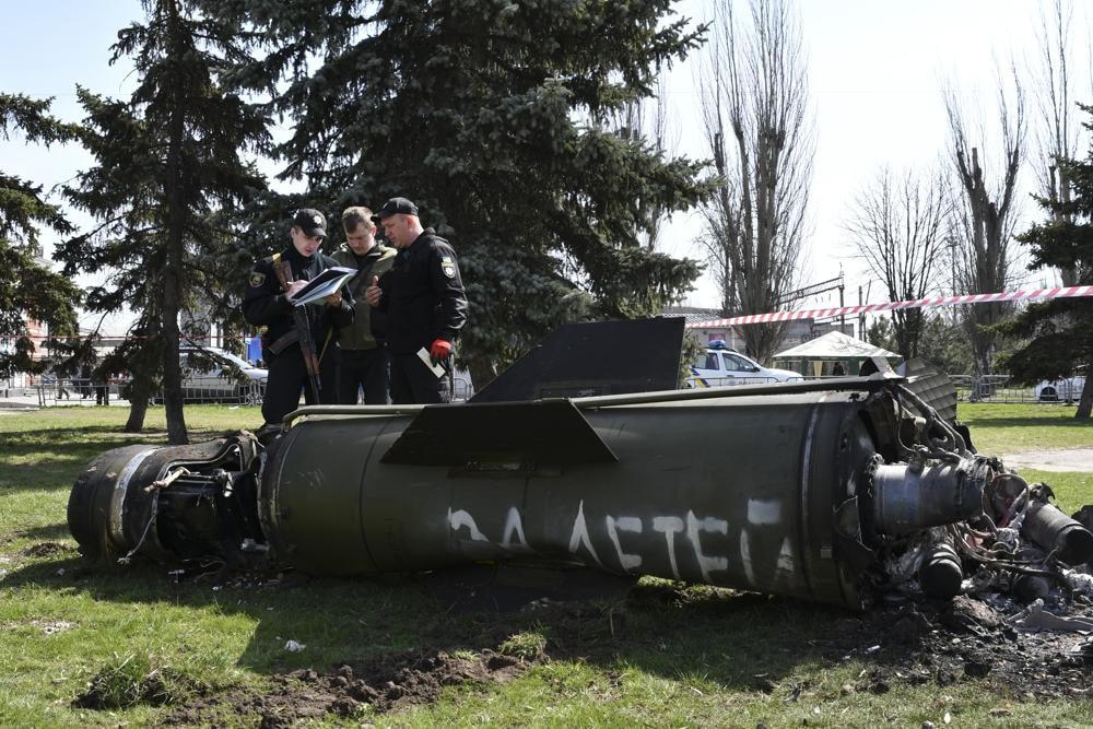 Các quân nhân Ukraine đứng cạnh mảnh vỡ tên lửa Tochka-U tại nhà ga xe lửa ở Kramatorsk, Ukraine. Ảnh: AP.