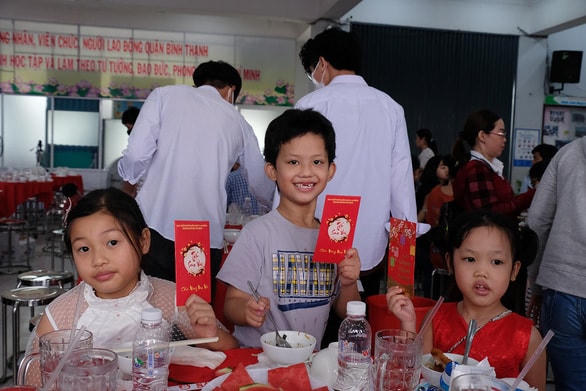 Niềm vui của các bé khi nhận bao lì xì tại chương trình Tết sum vầy do quận Bình Thạnh (TP HCM) tổ chức. Năm nay gia đình các bé không về Thanh Hóa đón Tết. Ảnh: Vũ Thủy.  