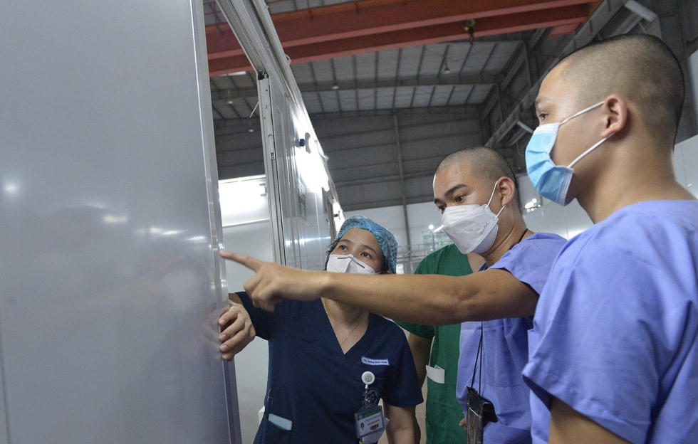 Các bác sĩ, điều dưỡng đang kiểm tra phòng bệnh nhân Covid-19. Ảnh: Tuổi Trẻ.