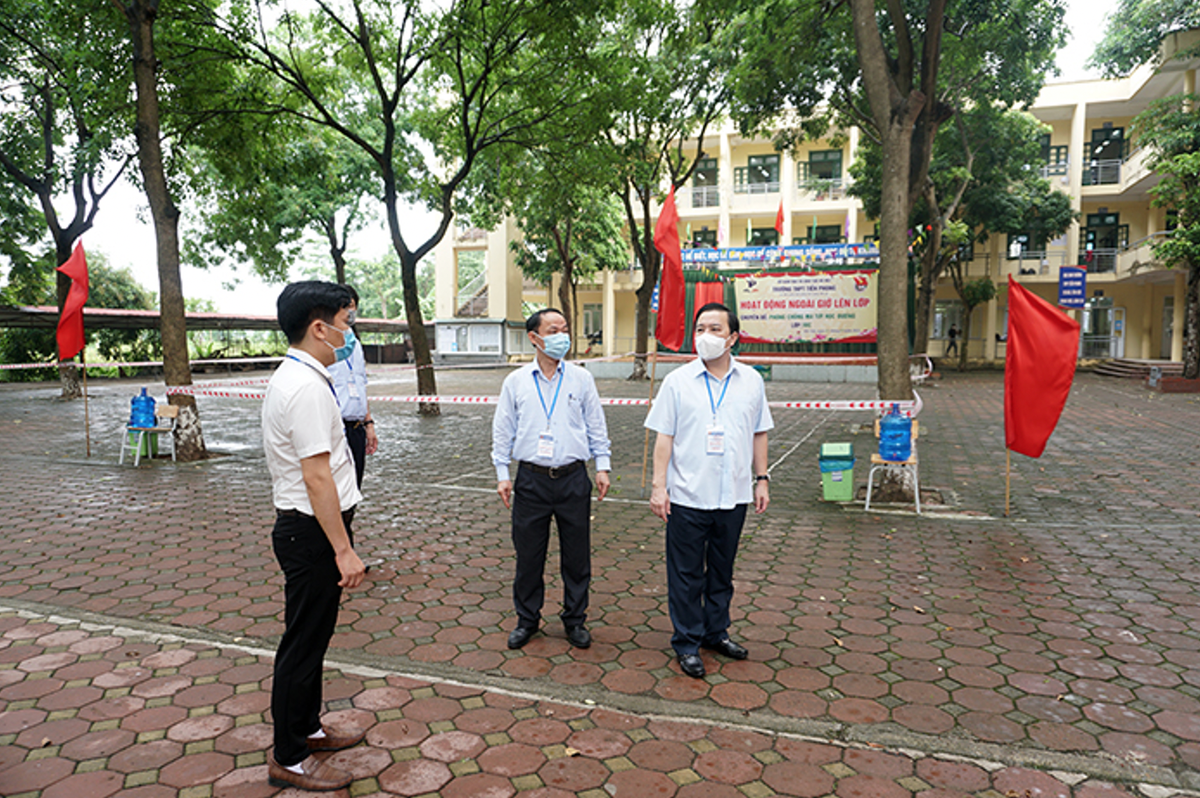 Ông Chử Xuân Dũng cùng đoàn kiểm tra các phòng thi tại điểm thi Trường THPT Tiền Phong (huyện Mê Linh).