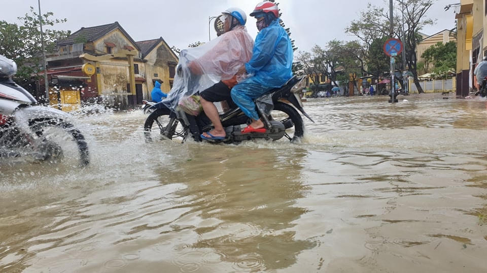 Người dân dùng xe máy đi qua những đoạn ít ngập nước.