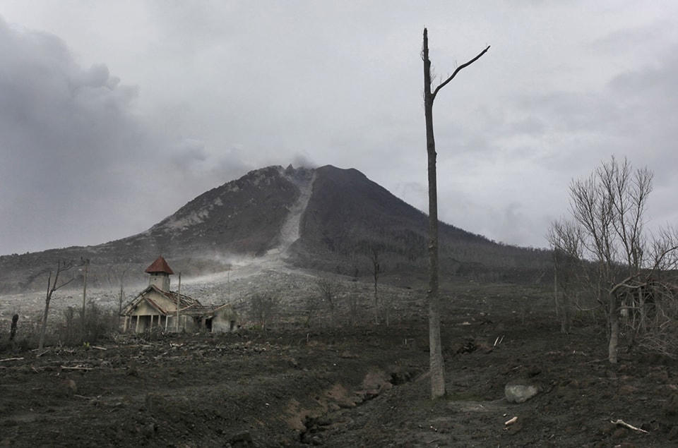 13. Một nhà thờ nhỏ bé bên cạnh núi Sinabung tại làng bỏ hoang của Simacem, Bắc Sumatra, Indonesia, ngày 16 tháng 11 năm 2015. Do Ngôi làng nằm trong khu vực hoạt động của núi lửa, nên dân cư buộc phải di tản đi nơi khác. Ảnh Binsar Bakkara / AP.​