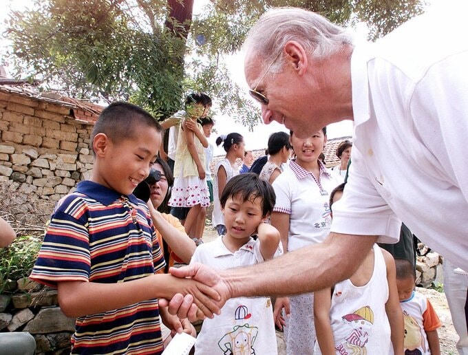 Joe Biden bắt tay một bé trai trong chuyến thăm làng Yanzikou, phía bắc Bắc Kinh, Trung Quốc, hồi năm 2001. Ảnh: Pool photo.  