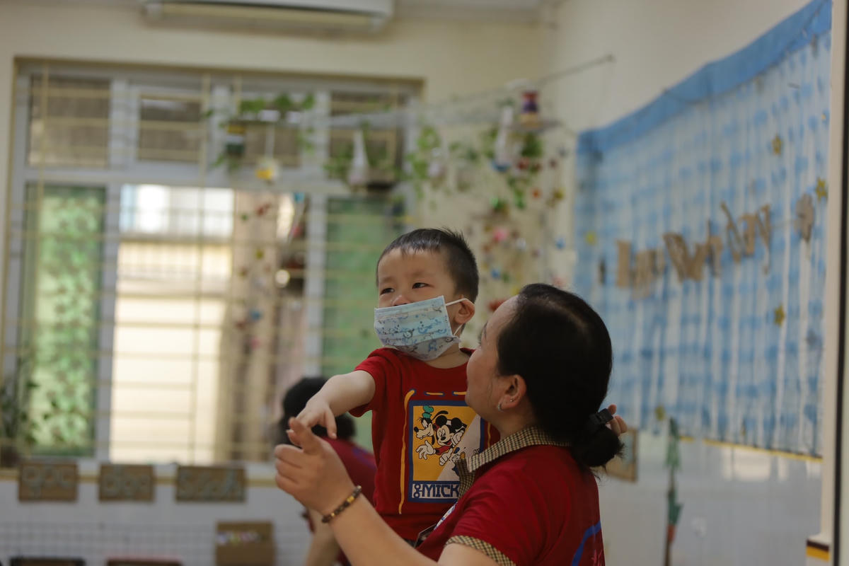Cô giáo Trường Mầm non Yên Hòa dỗ và làm quen với trẻ.