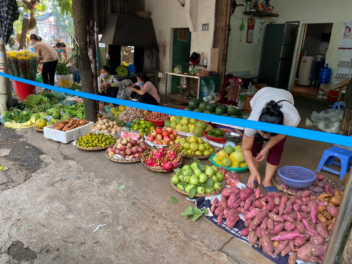 Một số cửa hàng phía bên ngoài khu chợ không dựng rào chắn nhưng thực hiện chăng dây để giữ khoảng cách với khách hàng. 