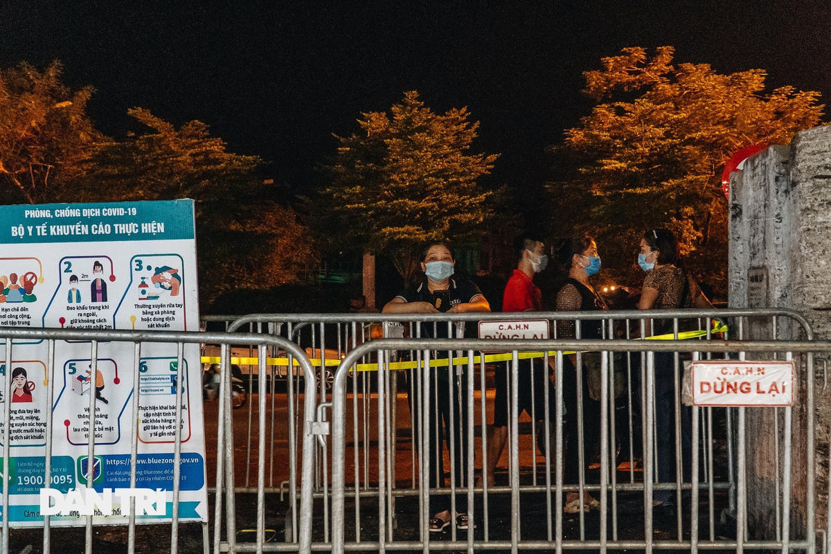 Lực lượng chức năng lập rào chắn toàn bộ cổng chính chợ Long Biên, khiến nhiều tiểu thương loay hoay tìm cách đưa hàng hóa vào trong chợ. Nguồn Dân Trí.