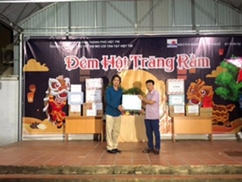Phóng viên thường trú Báo Đại Đoàn Kết trao quà cho đại diện Trung tâm Bảo trợ trẻ em mồ côi tàn tật Việt Trì. 