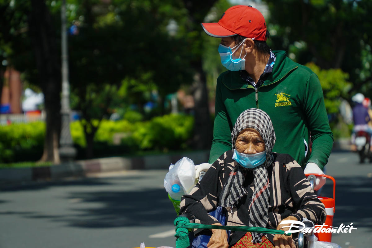 Người con ngoái nhìn theo hướng của nhóm phát cơm như muốn cảm ơn về phần cơm nóng đang cầm trên tay.