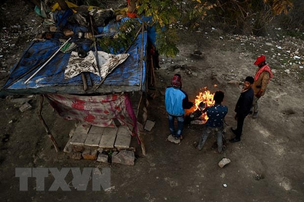 Người vô gia cư đốt lửa sưởi ấm tại New Delhi, Ấn Độ, ngày 29/1/2022. (Ảnh: AFP/TTXVN).