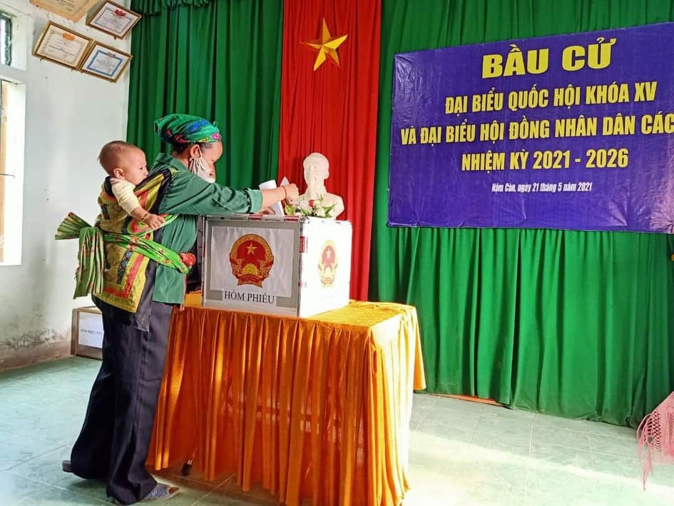 Người dân xã Nậm Càn, huyện Kỳ Sơn địu con đi bầu cử (Ảnh: Lê Thạch).