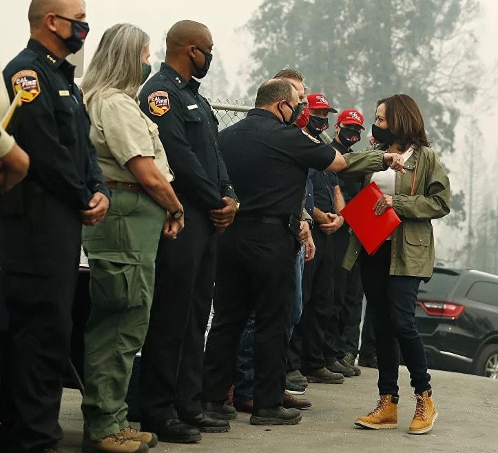 Ứng cử viên Phó Tổng thống của đảng Dân chủ, Thượng nghị sĩ Kamala Harris, D-California, chạm khuỷu tay vào những người phản ứng đầu tiên khi cô được thông báo tóm tắt về Vụ cháy Creek tại trường tiểu học Pine Ridge, ngày 15/9/2020 ở Auberry, California. Harris với một chiếc áo khoác bình thường- quần jean, hoàn chỉnh với bốt Timberland màu nâu cổ điển.  