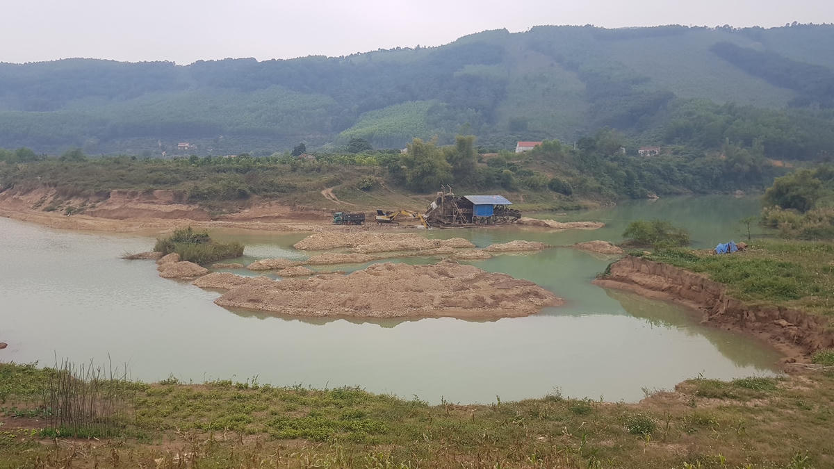 Khai thác khoáng sản lòng sông gây sạt lở đất canh tác. Ảnh: Nam Anh.