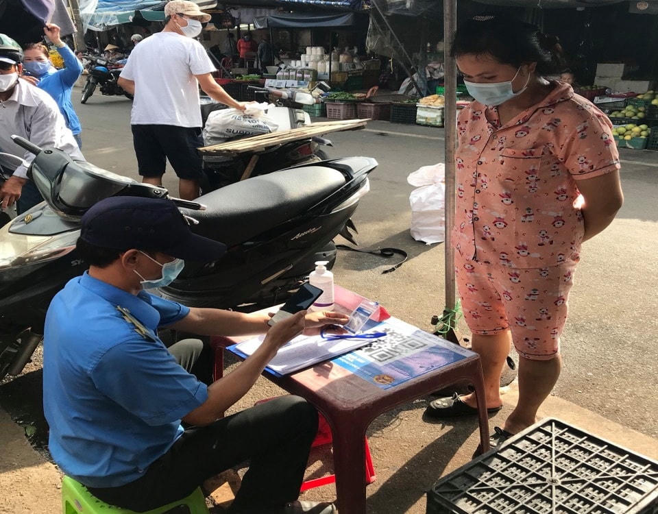 Tiểu thương đang thực hiện quét mã QR qua hình thức "Thẻ kiểm soát dịch bệnh" tại chợ Đông Ba, TP Huế. Ảnh: Xuân Sơn.