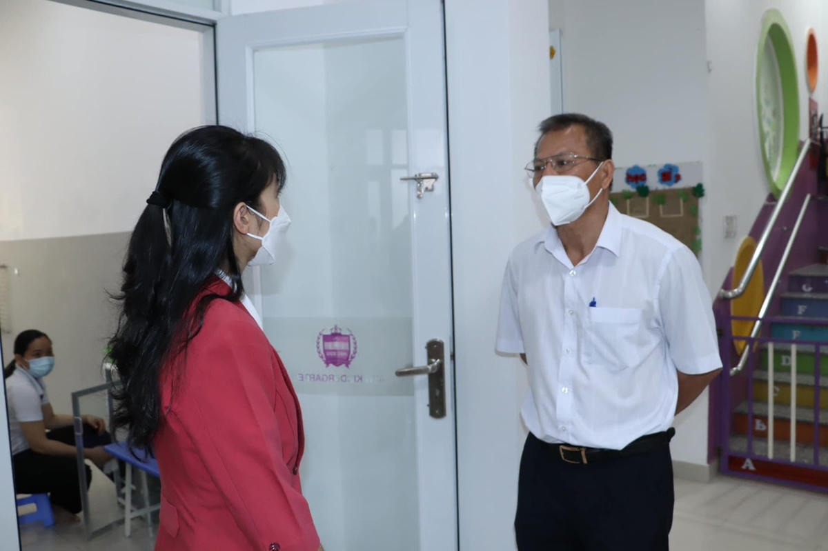 Phó giám đốc Sở GD-ĐT Đồng Nai Võ Ngọc Thạch (bên phải) kiểm tra, trao đổi với một giáo viên về công tác phòng chống dịch của nhà trường.
