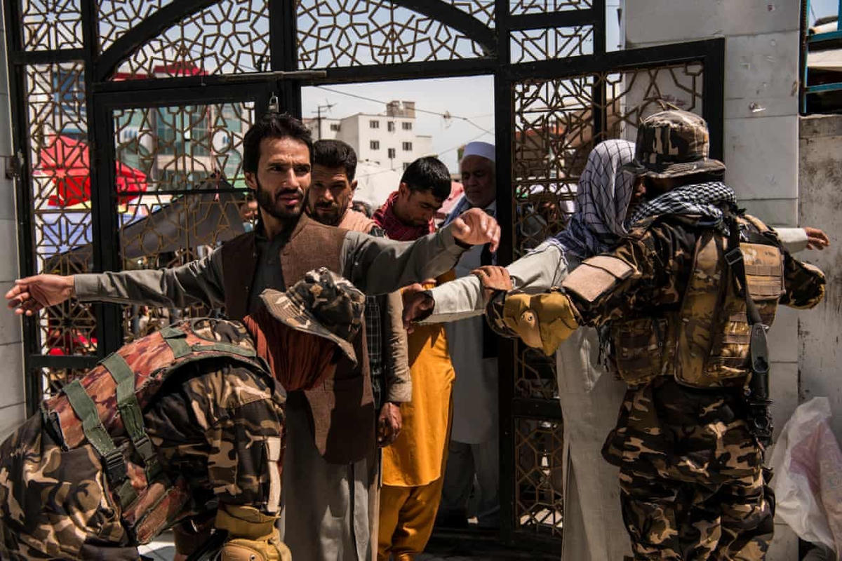 Lực lượng Taliban khám xét người dân trước khi cho họ vào nhà thờ Hồi giáo Pul-e-Khishti ở thủ đô Kabul để cầu nguyện, lần đầu tiên kể từ sau khi các tay súng nắm quyền kiểm soát. (Ảnh: Andrew Quilty)