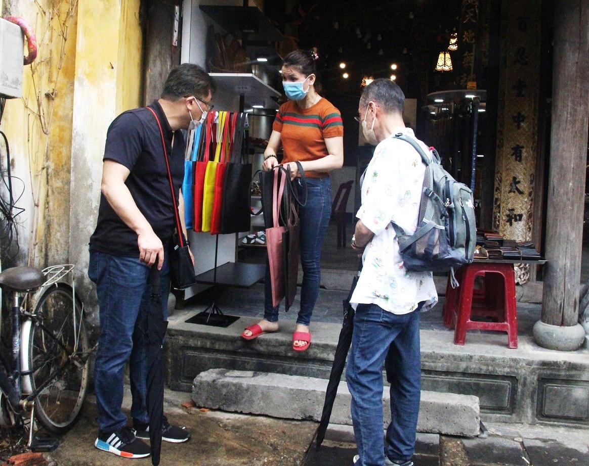 Du khách nước ngoài mua quà lưu niệm ở một cửa hàng hàng.