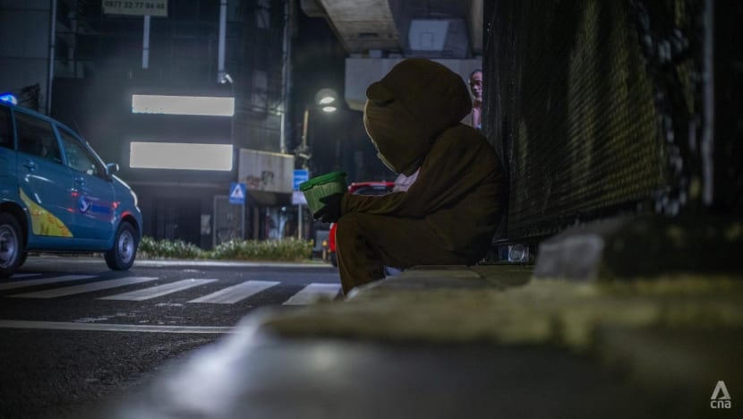 Một người mặc trang phục gấu ngồi trên vỉa hè tại một ngã tư đông đúc ở Jakarta, Indonesia. Ảnh: CNA.