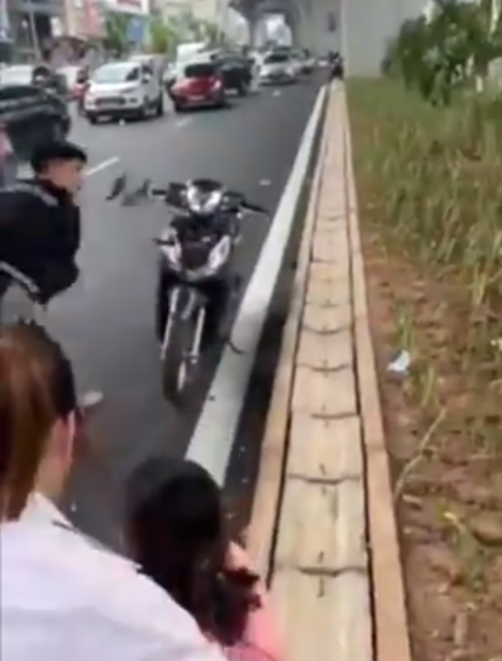 Nam thanh niên đập phá chiếc xe máy của người đi đường. Ảnh cắt từ Clip.