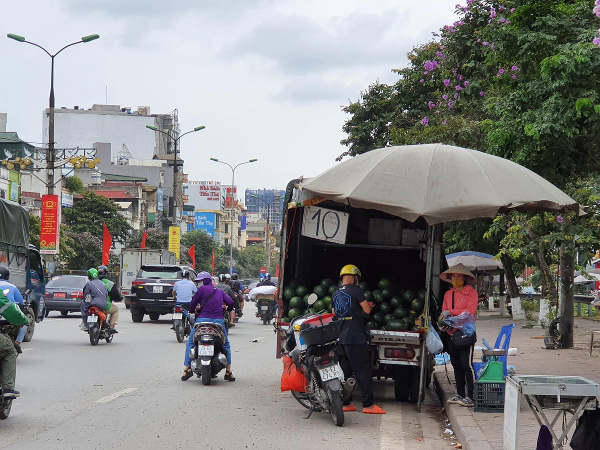 Cứ vài trăm mét lại bắt gặp hình ảnh những chiếc xe ô tô tải buôn bán hoa quả ngay trên lề đường.