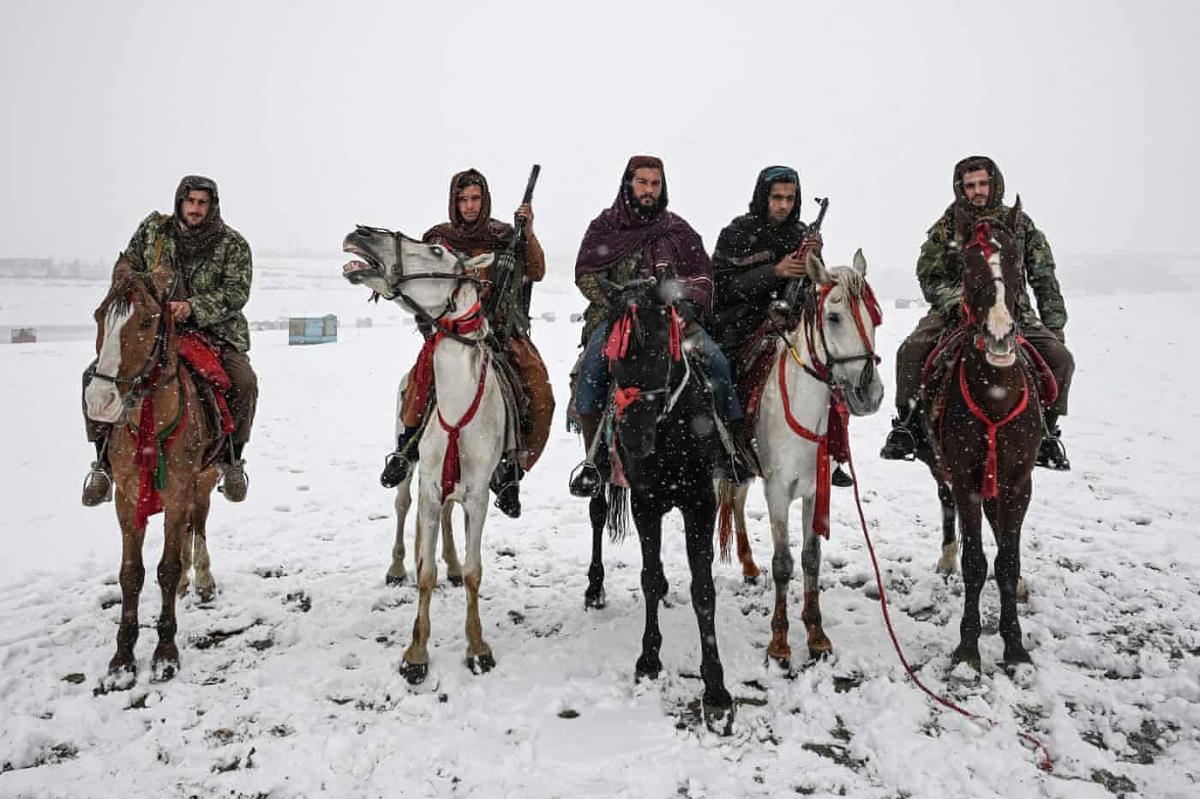 Các tay súng Taliban cưỡi ngựa trong trận tuyết rơi ở hồ Qargha. Ảnh: Mohd Rasfan / AFP / Getty.