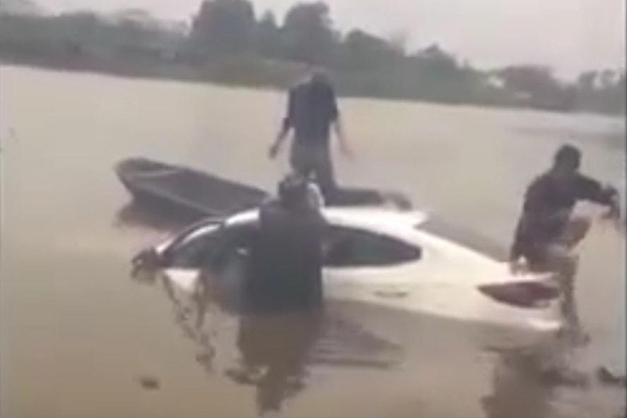 Lực lượng chức năng trục vớt chiếc xe ô tô và thi thể nạn nhân.