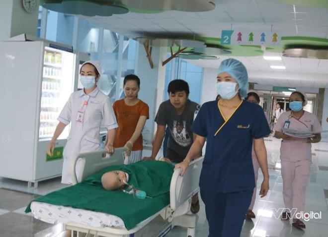 5h30 sáng nay (15/7), hai bé gái song sinh dính nhau Trúc Nhi - Diệu Nhi bắt đầu được chuyển vào phòng phẫu thuật, chuẩn bị tách rời. Bố mẹ quyến luyến đi theo 2 em cho tới cửa phòng phẫu thuật. (Ảnh: VTV Digital).