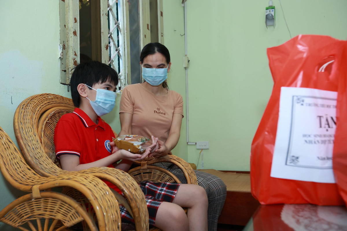 Niềm vui của cháu Phạm Gia Trung khi nhận bánh nướng do chính cô tổng phụ trách làm.