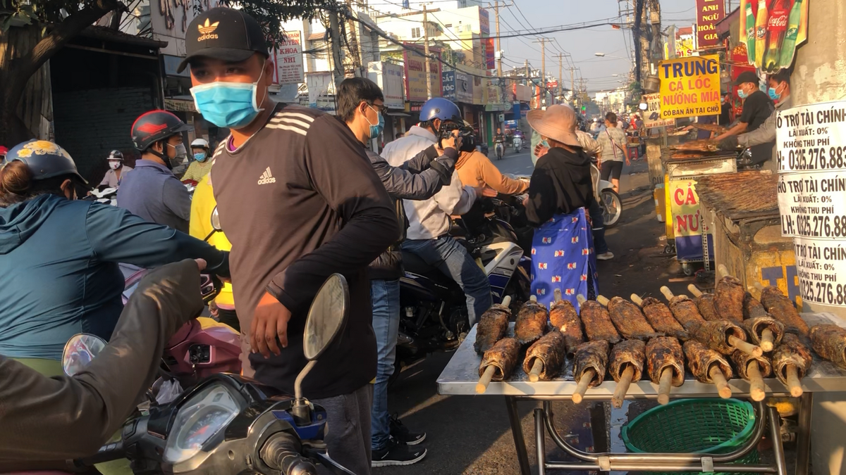 Người dân xếp hàng, chen lấn dừng mua cá lóc nướng. Tại khu vực TP HCM ngày hôm nay, ngoài khu vực đường Tân Kỳ Tân Quý thì nhiều nơi khác cũng có bán cá lóc nướng. Đây là một trong những mặt hàng được nhiều người tìm mua nhất.