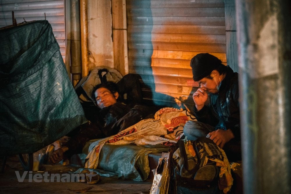 Nhiều lúc buồn ngủ quá mà chưa có việc, nhiều người lao động lại tranh thủ làm một giấc ngoài đường. (Ảnh: Minh Hiếu/Vietnam+).