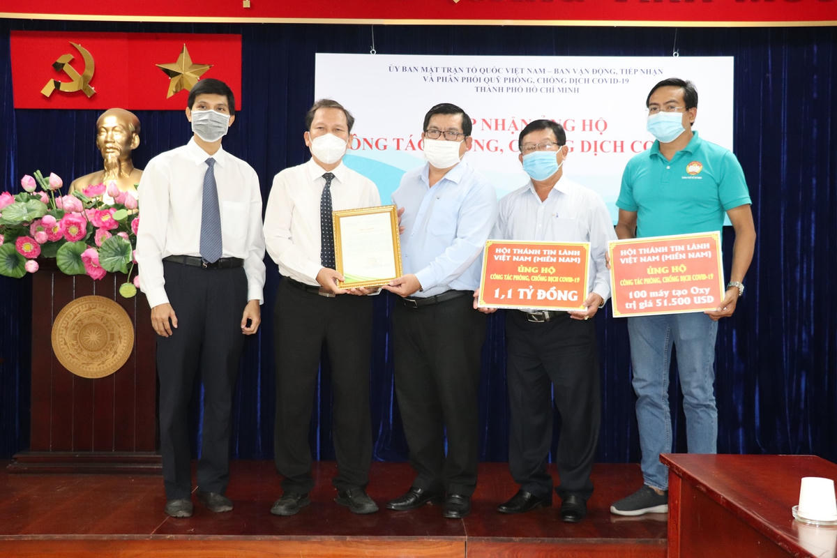 Mục sư Phan Vĩnh Cự (thứ 2, từ trái qua) trao bảng tượng trưng ủng hộ công tác phòng, chống dịch Covid-19 Thành phố.