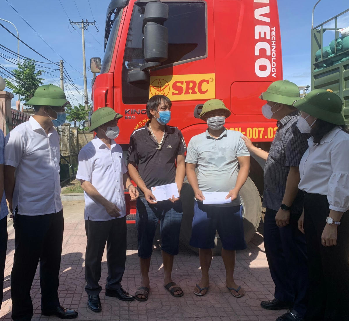 Chủ tịch Ủy ban MTTQ tỉnh Hà Tĩnh Trần Nhật Tân (thứ hai từ phải sang) động viên lái xe chở hàng ủng hộ đồng bào miền Nam chống dịch.