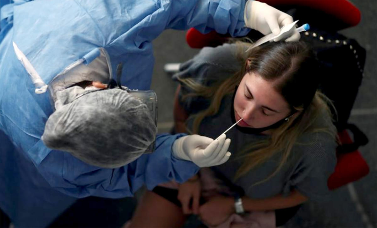 Nhân viên y tế lấy mẫu xét nghiệm Covid-19 tại một bến xe buýt ở Buenos Aires, Argentina. Ảnh: Reuters.
