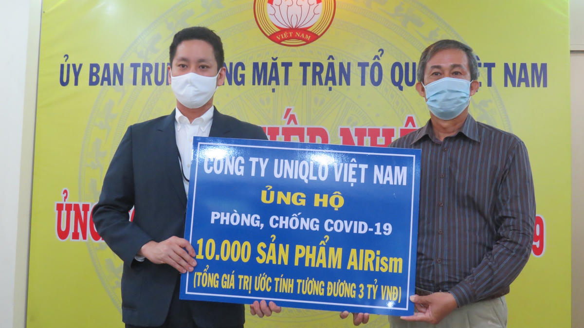 Ông Võ Văn Thiện (phải) nhận hiện vật ủng hộ "cuộc chiến" chống covid-19