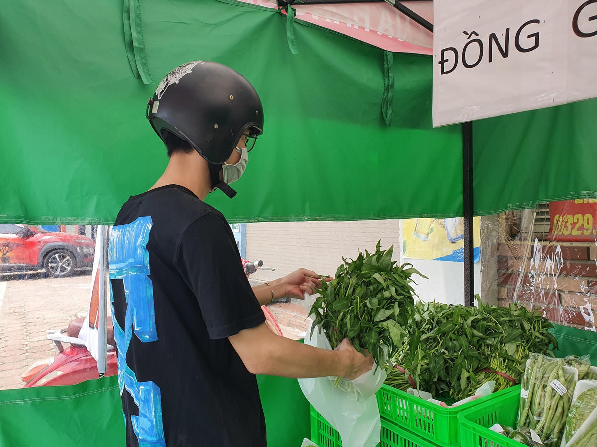 Anh Vũ Trọng Nghĩa (22 tuổi, Khương Đình - Thanh Xuân) đang tự lấy rau tại cửa hàng không người bán trên đường Thượng Đình. Anh Nghĩa cho biết, tình cờ trên đường đi mua thực phẩm chuẩn bị cho bữa trưa thấy có cửa hàng này, lại đa dạng các loại rau củ nên ghé vào mua.