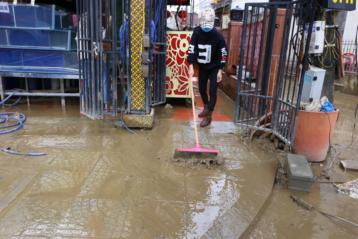 Người dân phố cổ Hội An dọn dẹp bùn đất sau lũ.