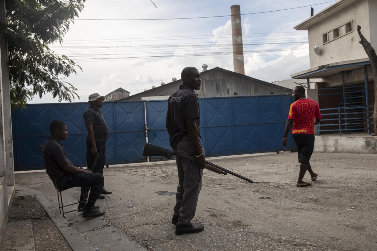Các nhân viên an ninh có vũ trang đứng canh tại lối vào chính của khu công nghiệp Shodecosa, ở Port-au-Prince, Haiti.