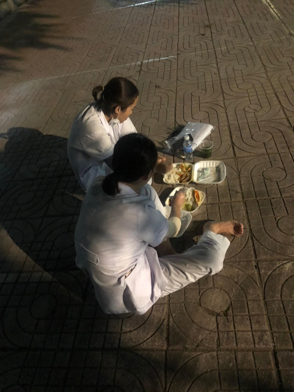 Phút ngơi tay ăn vội miếng cơm hộp nguội ngắt của các nữ chiến binh áo trắng.  