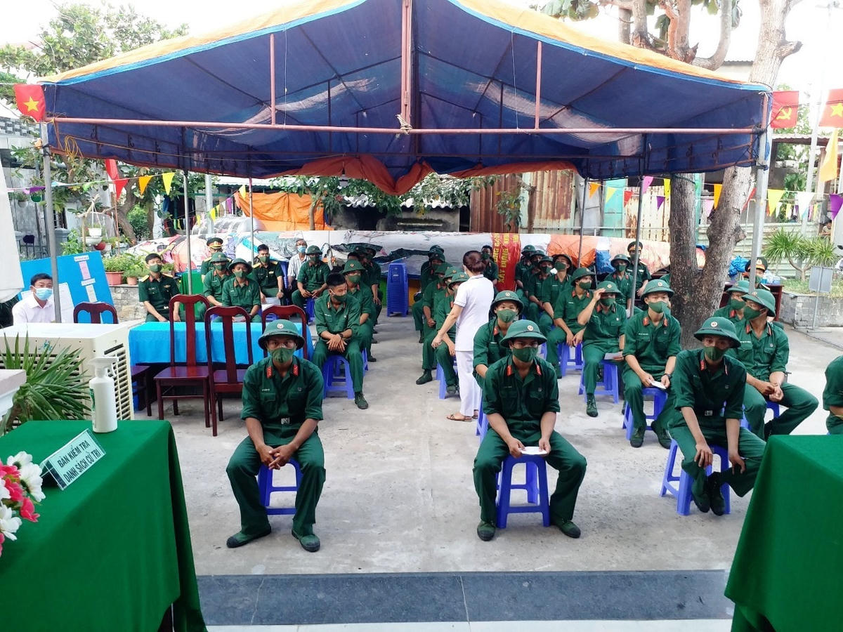 Cử tri xã đảo Tân Hiệp ngồi giãn cách khi vào điểm bỏ phiếu.